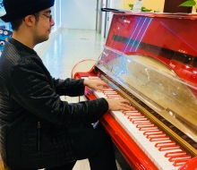 Carlo Aspri in Beijing, China playing on a special red and white coloured piano with red and white keys.
