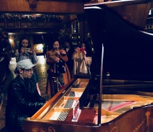 Carlo Aspri playing the piano at the renowned VIP Exclusive Club "East Wine Cellar" while Carlo's fans take photos and videos of his performance.