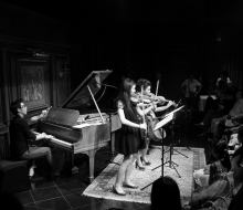 Carlo Aspri sings and plays piano while being accompanied by a group of female violin musicians in China.